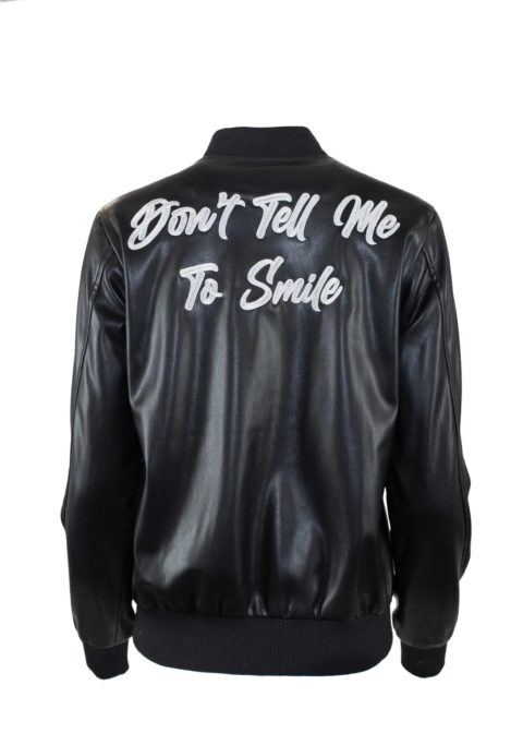 A Hilary MacMillan jacket that says "Don't tell me to smile" on the back