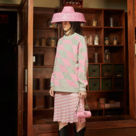 private policy chinese designers woman in pink hat grey and pink sweater and checkered pink skirt with pink purse
