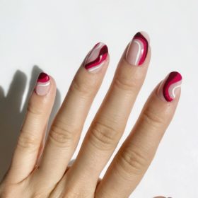 nails with abstract red white and berry waves and a neutral base