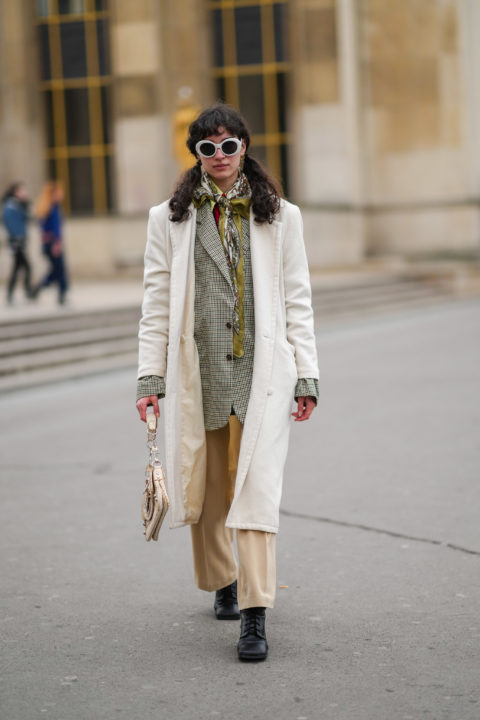woman in whie sunglasses, jacket, khaki scarf beige pants
