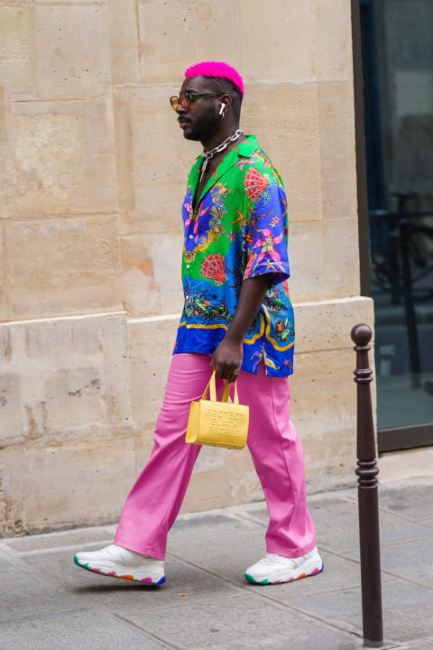 man with pink hair and multi coloured pattern button down pink pants and yellow handbag inspo for what to wear to pride 2022