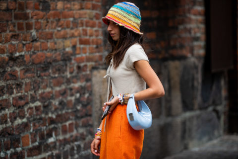 woman with white shirt orange shorts blue purse inspo for what to wear to pride 2022