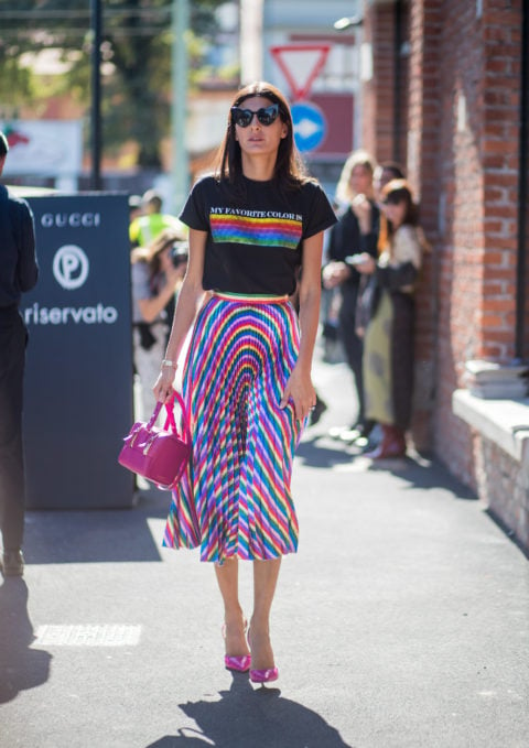 woman with a black shirt with a rainbow stripe and a multicoloured blue and red skirt