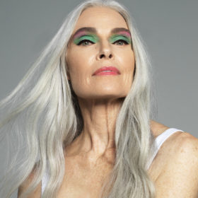 An older model wearing a colourful eye makeup look