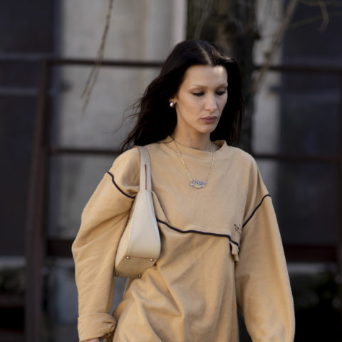 bella hadid with bleached eyebrows in a sweater and purse walking in Milan