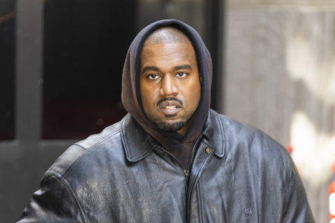 Kanye West, who was dropped by adidas on October 25 for making antisemitic comments, is pictured here wearing a black hooded sweatshirt and black leather jacket