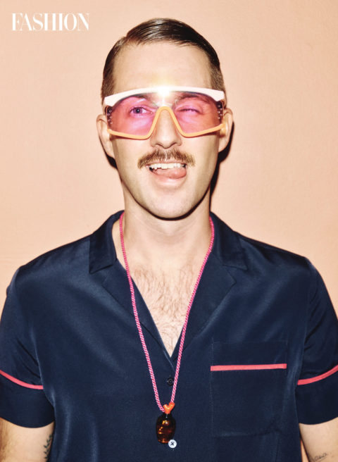 eyewear collection: Grist poses in light pink sunglasses and his tongue out