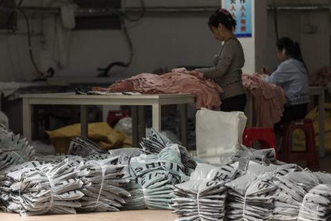 Shein packages in a factory in front of garment workers