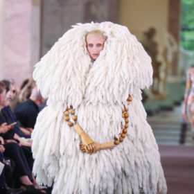 A model in a white fuzzy coat at the Schiaparelli Fall 2023 couture show