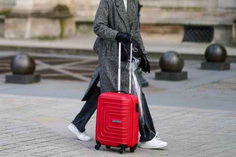 Woman carrying a red bag, best carry-on travel bags